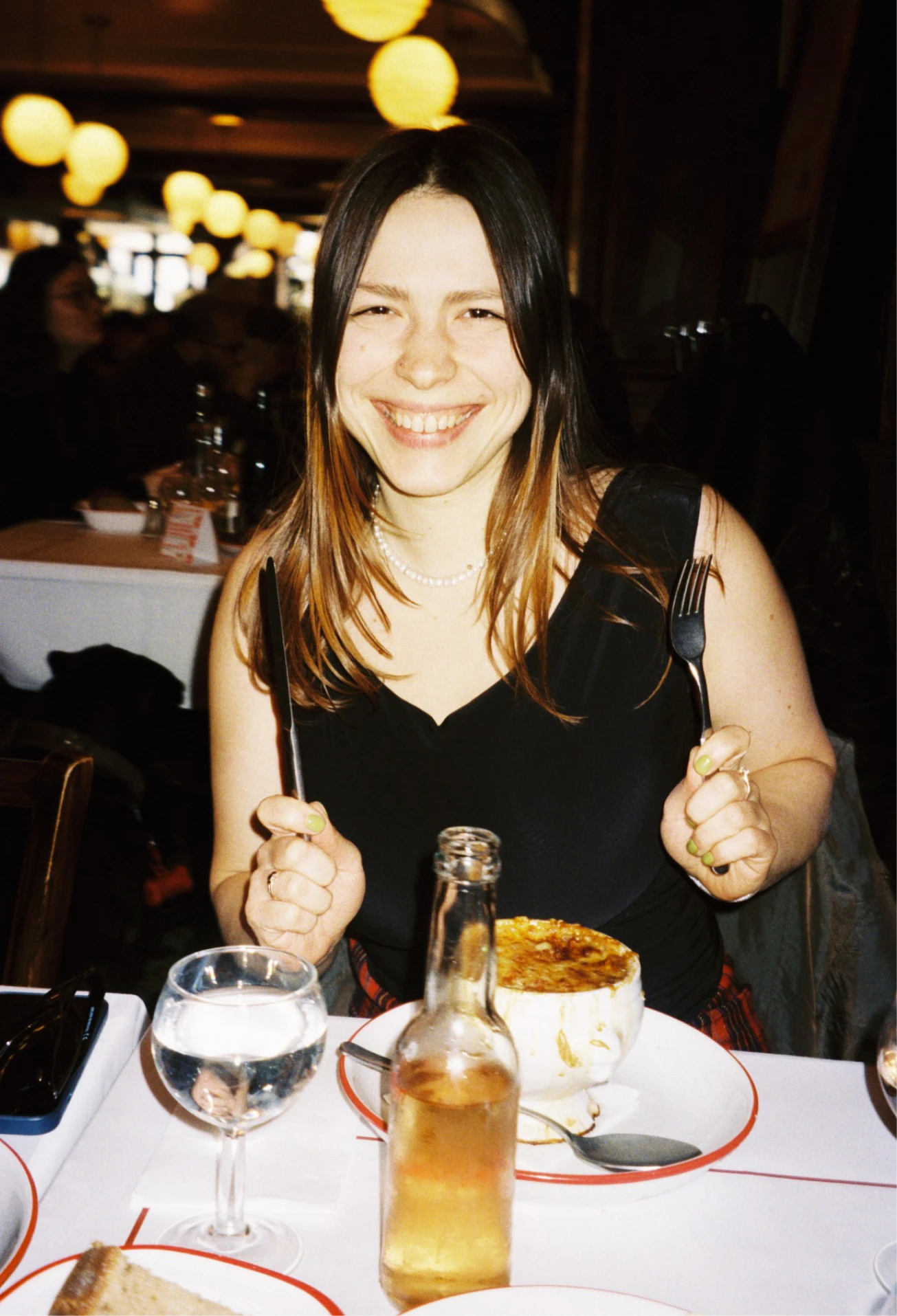 Sasha smiling at a restaurant table